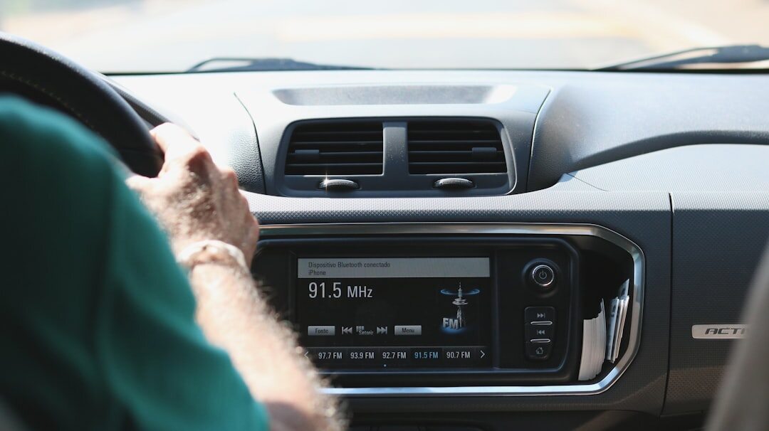 person tuning radio in car